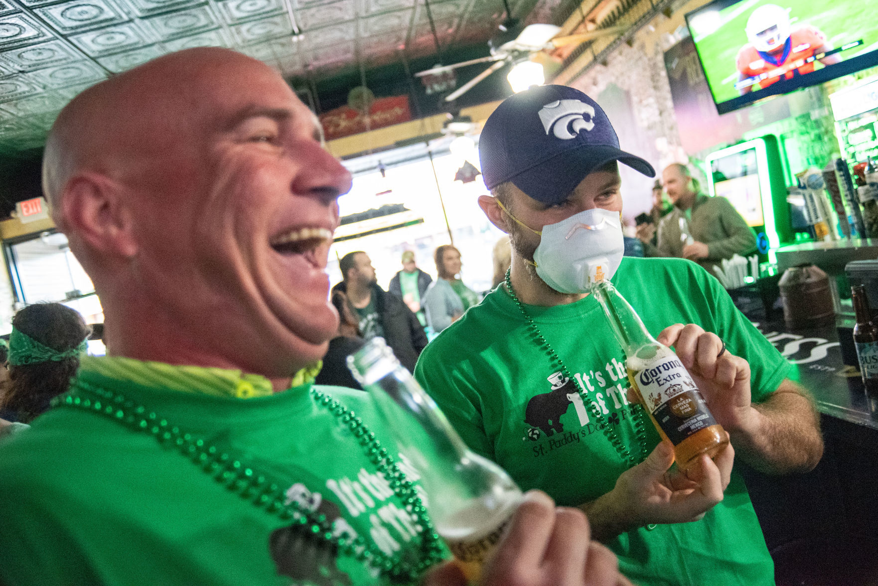 Kyle Powers uses a straw to drink Corona beer through his face mask while sharing a beer next to James Salyers at OÕMalleyÕs.